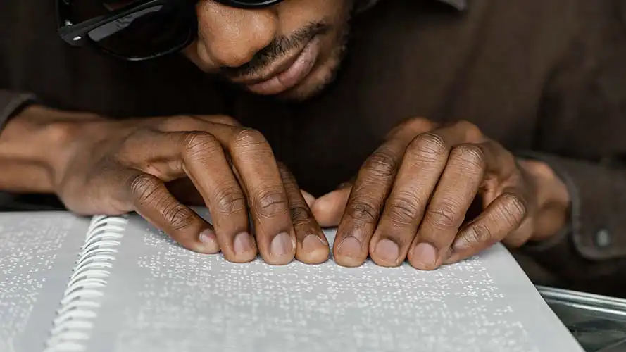 Man reading a Braille document.